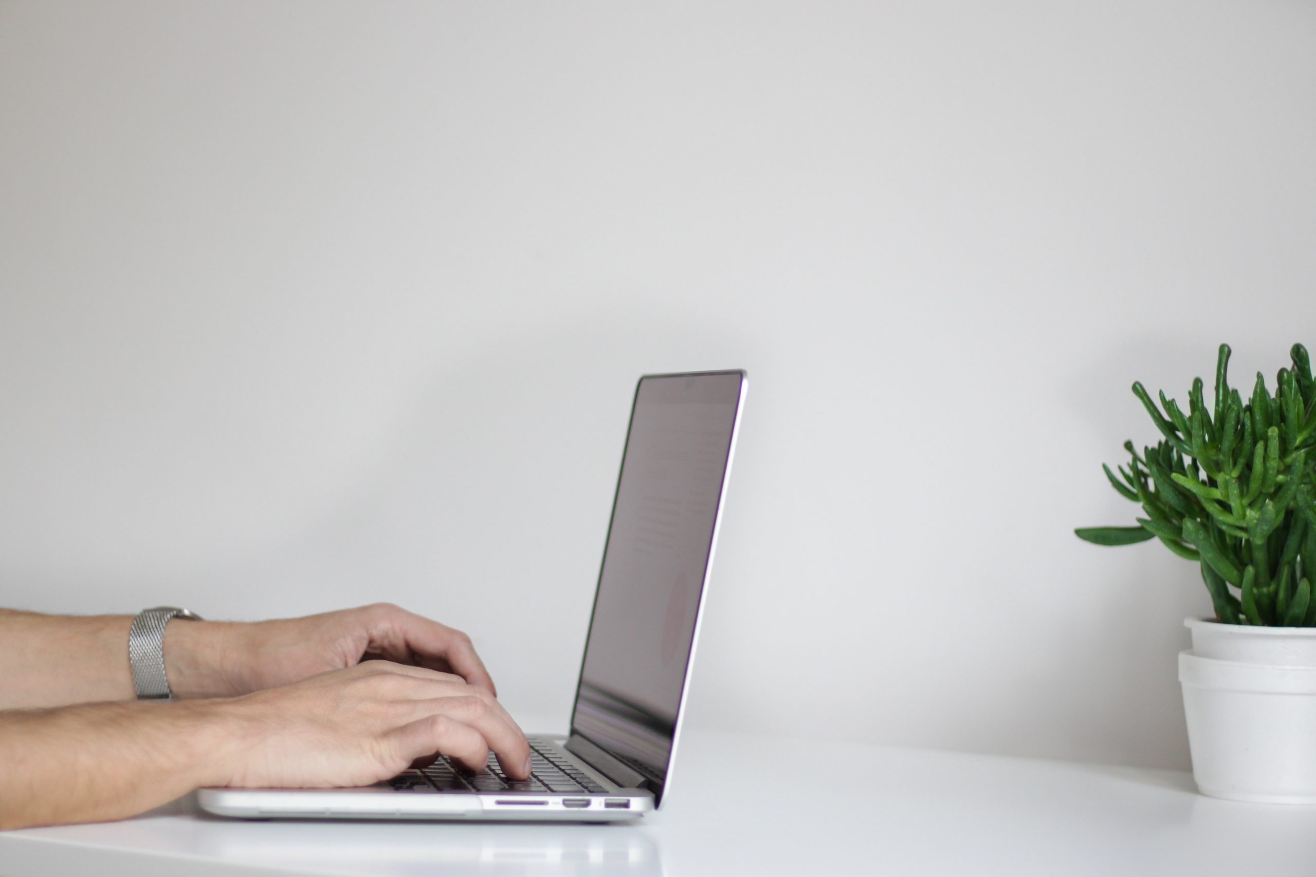 Someone typing on a laptop completing a checklist